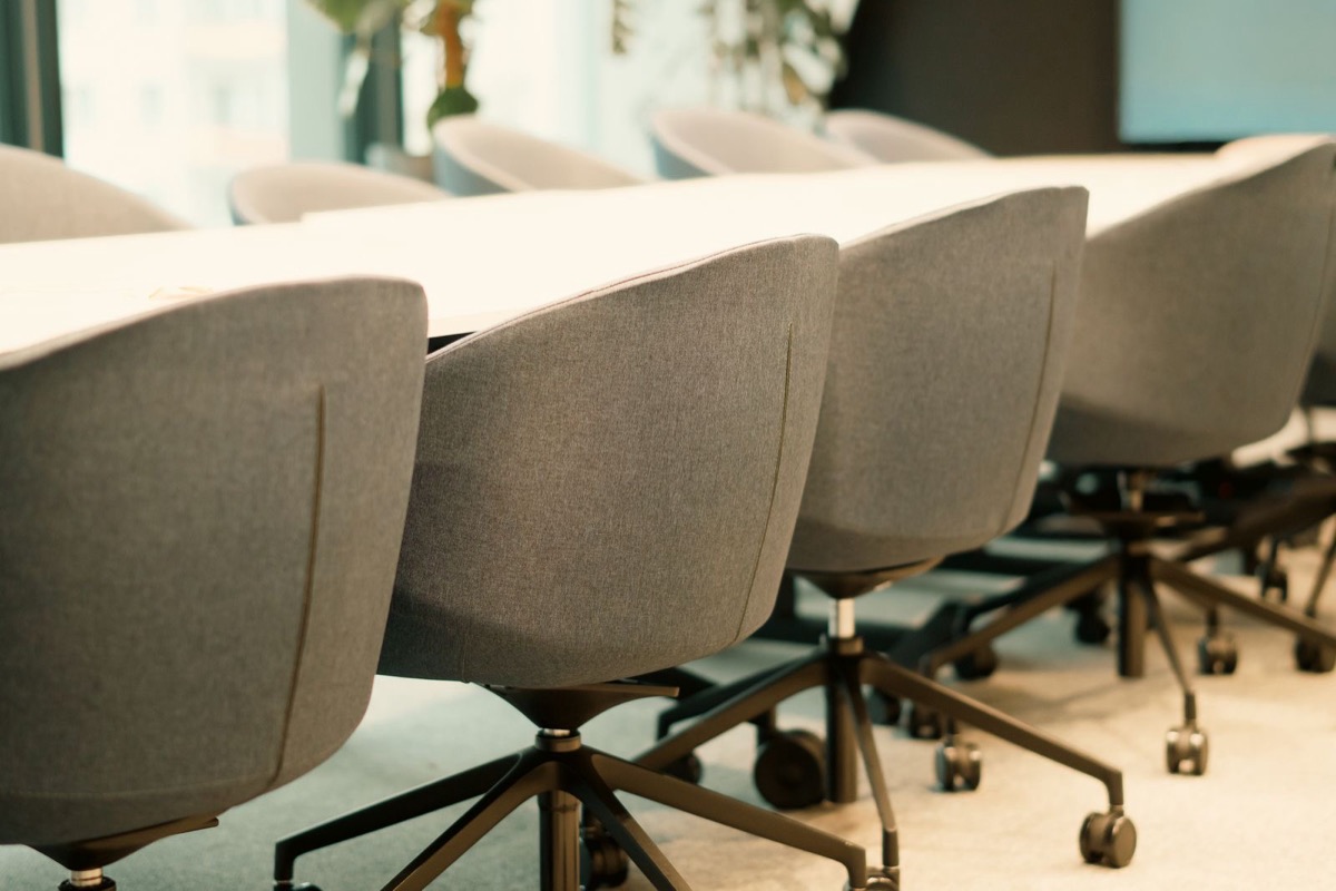 An empty meeting room with a long table and chairs in soft daylight